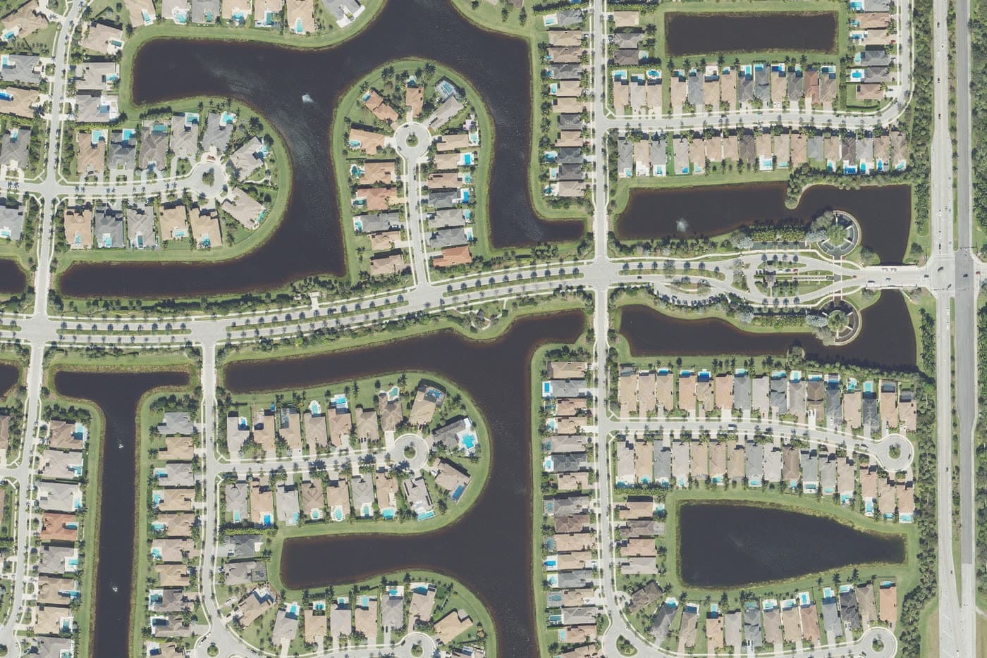 The Bridges, Delray Beach, from above: tile-roofed homes on lake-front lots around the gated entrance